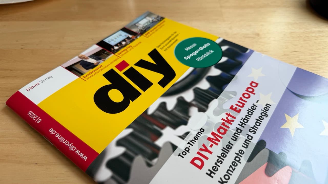 Die August-Ausgabe 8|2026 des Fachmagazins diy mit dem Top-Thema DIY-Markt Europa liegt auf einem Holztisch